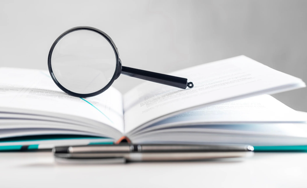 Magnifying glass on top of open books.